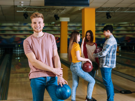 Young man with friends in bowling clubの写真素材
