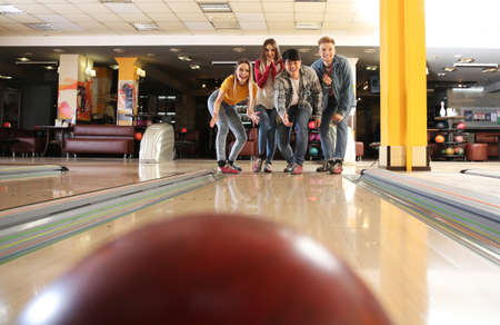 Friends playing bowling in clubの写真素材