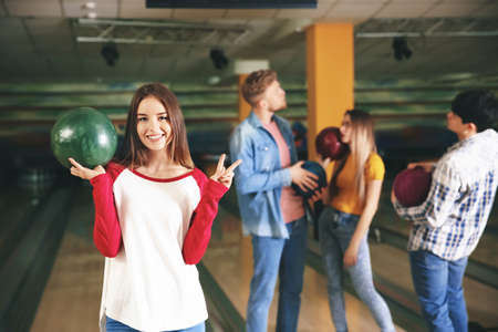 Young woman with friends in bowling clubの写真素材