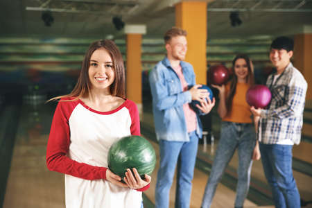 Young woman with friends in bowling clubの写真素材