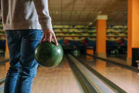 Young man playing bowling in clubの写真素材