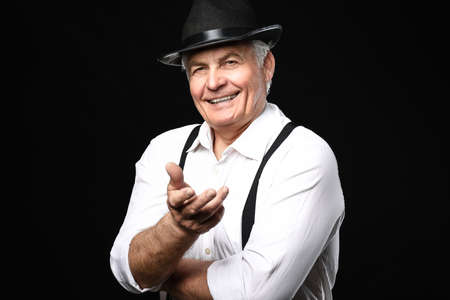 Portrait of stylish senior man on dark background