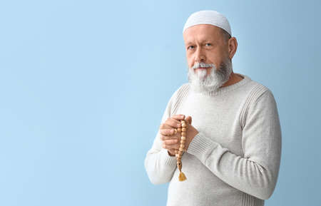 Senior Muslim man praying against light backgroundの写真素材