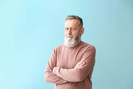 Portrait of handsome senior man on color background