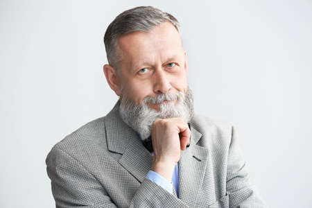 Portrait of handsome senior man on light background