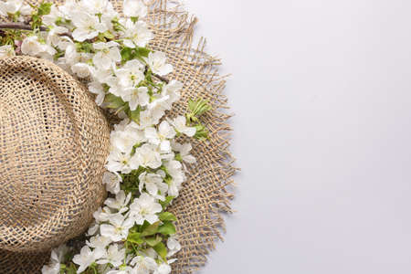 Hat and beautiful flowers on white background
