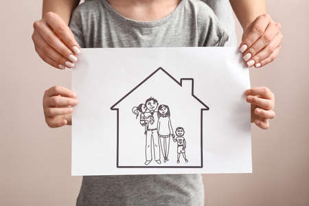 Woman and child with drawing of family. Concept of adoptionの写真素材