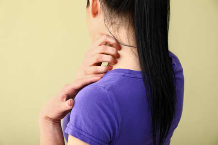 Young woman with skin allergy on color background
