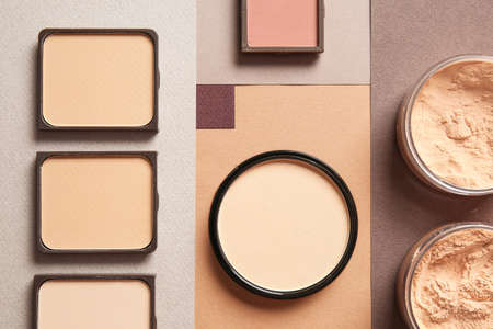 Different facial powder on color background