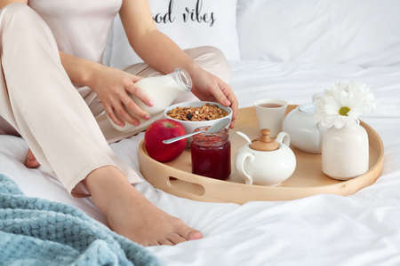 Woman having tasty breakfast on bedの写真素材