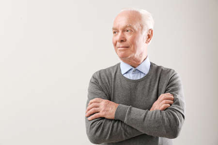 Portrait of elderly man on gray background