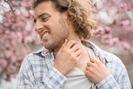 Young man with skin allergy on spring dayの写真素材
