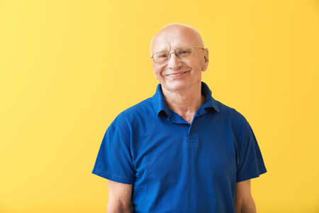 Portrait of happy elderly man on color background