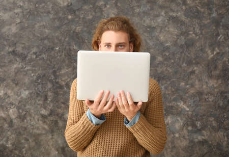 Male programmer with laptop on grunge backgroundの写真素材