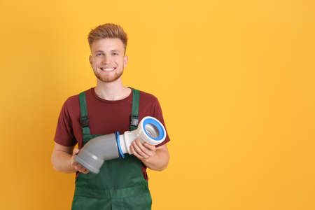Handsome young plumber on color backgroundの写真素材