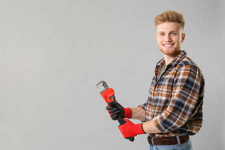 Handsome plumber on gray backgroundの写真素材