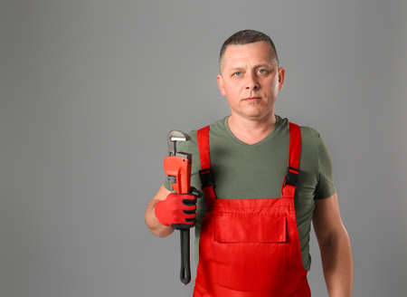 Handsome plumber on gray backgroundの写真素材