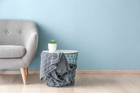 Armchair and table near color wall in roomの写真素材