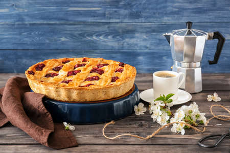 Composition with tasty cherry pie and cup of coffee on wooden tableの写真素材