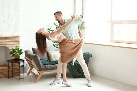 Dancing young couple at homeの写真素材