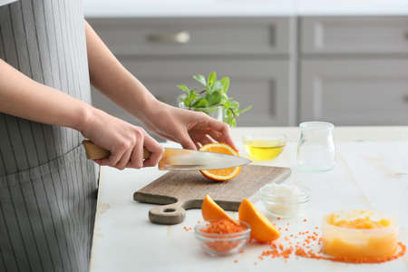 Woman preparing body scrub at table in kitchenの写真素材