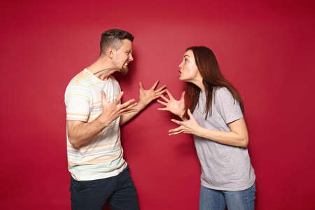 Quarreling young couple on color backgroundの写真素材