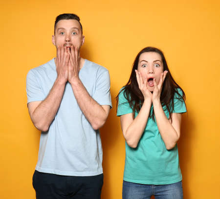 Afraid young couple on color backgroundの写真素材