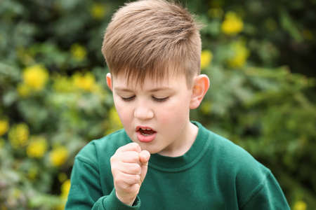 Boy having asthma attack outdoors on spring day
