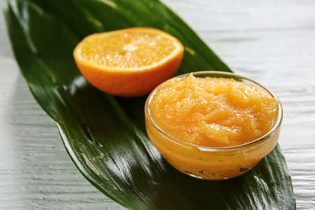 Bowl with orange body scrub on white wooden backgroundの写真素材