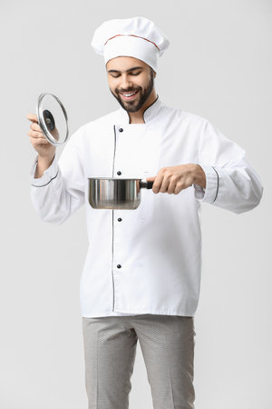Handsome male chef with pot on white backgroundの写真素材