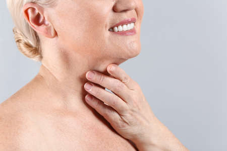 Mature woman on light background, closeup