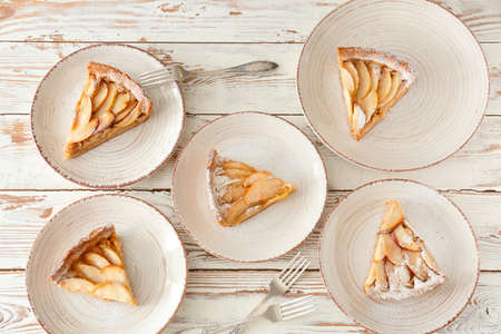 Plates with tasty apple pie on white wooden backgroundの写真素材