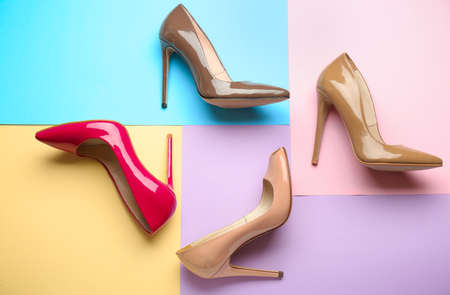 Different stylish high heeled shoes on color backgroundの写真素材