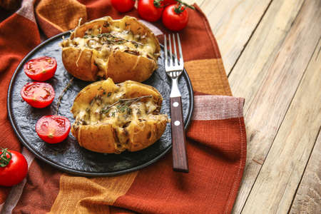 Plate with tasty stuffed potato on wooden tableの写真素材