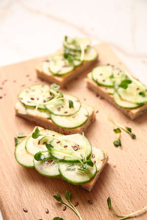 Tasty cucumber sandwiches on wooden boardの写真素材