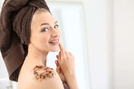 Young woman with body scrub on her body at homeの写真素材