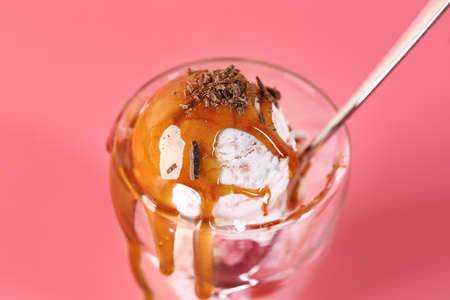Glass with tasty ice cream on color background