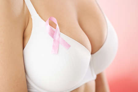 Young woman with pink ribbon, closeup. Breast cancer awareness conceptの写真素材