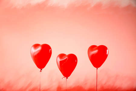 Heart-shaped air balloons on color backgroundの写真素材
