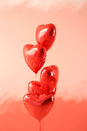 Heart-shaped air balloons on color backgroundの写真素材