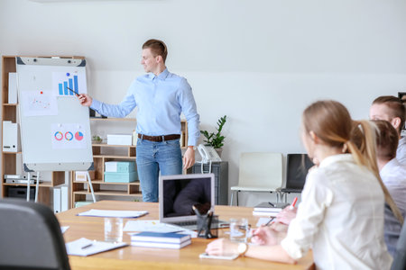 Young businessman giving presentation at meeting in officeの写真素材