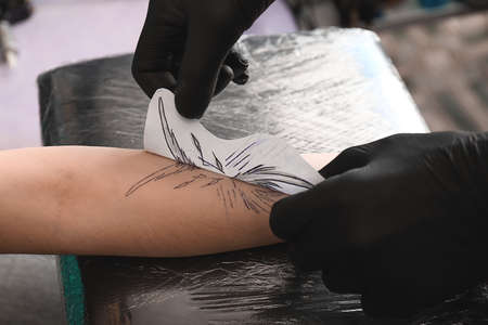 Professional artist making tattoo in salonの写真素材