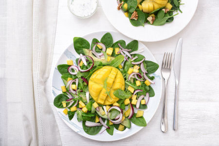 Plate with tasty mango salad on white tableの写真素材