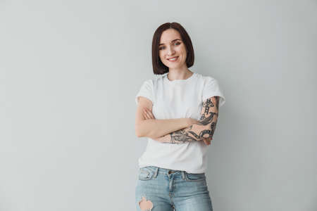 Stylish tattooed woman on light backgroundの写真素材