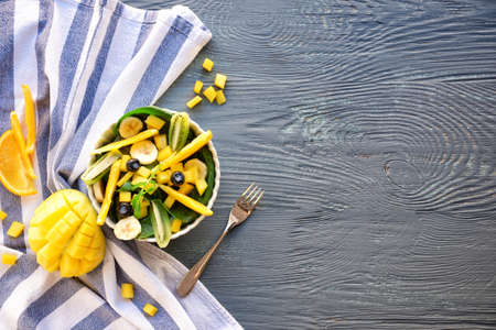 Bowl with tasty mango salad on wooden tableの写真素材
