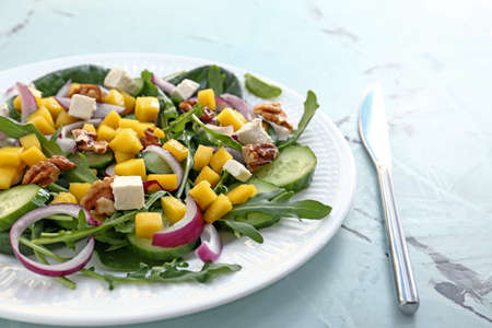 Plate with tasty mango salad on tableの写真素材
