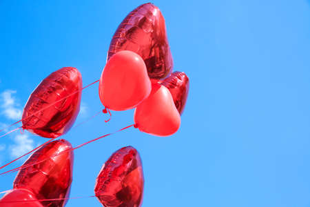 Heart shaped air balloons on blue sky backgroundの写真素材