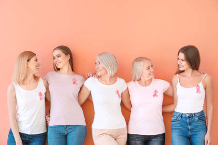 Beautiful women of different ages with pink ribbons on color background. Breast cancer conceptの写真素材