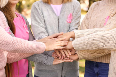 Women of different ages putting hands together outdoors. Breast cancer conceptの写真素材