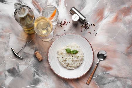 Plate with tasty risotto and wine on color backgroundの写真素材